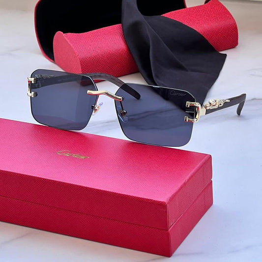 Cartier Shades with black tinted lenses and gold accents displayed with a red Cartier case and cleaning cloth
